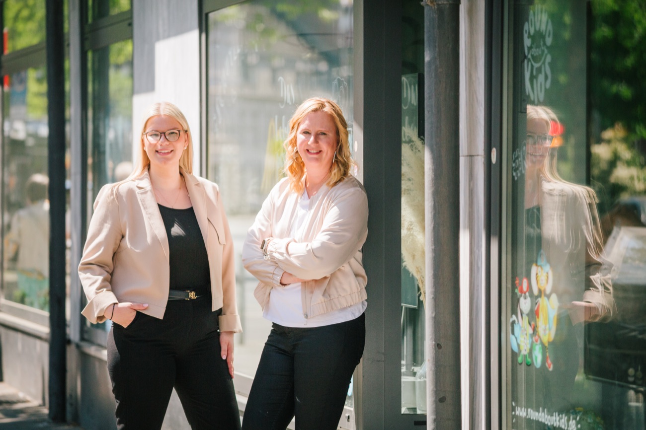 Sina Waris Hülk und Doris Greinert vor einer Glasfassade